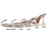 Clear high-heeled shoes with heel height measurements on a white background
